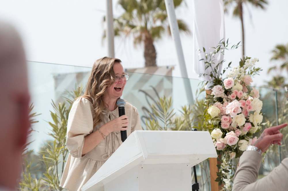 Lizette spreekt lachend de ceremonie uit achter het spreekgestoelte
