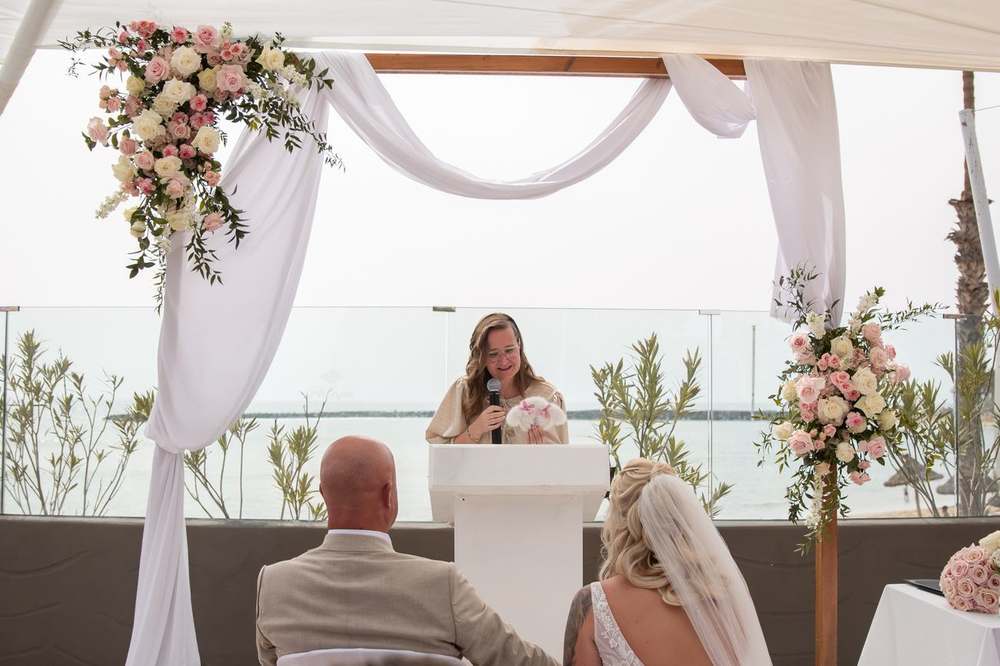 Lizette spreekt de ceremonie uit met zeezicht op de achtergrond